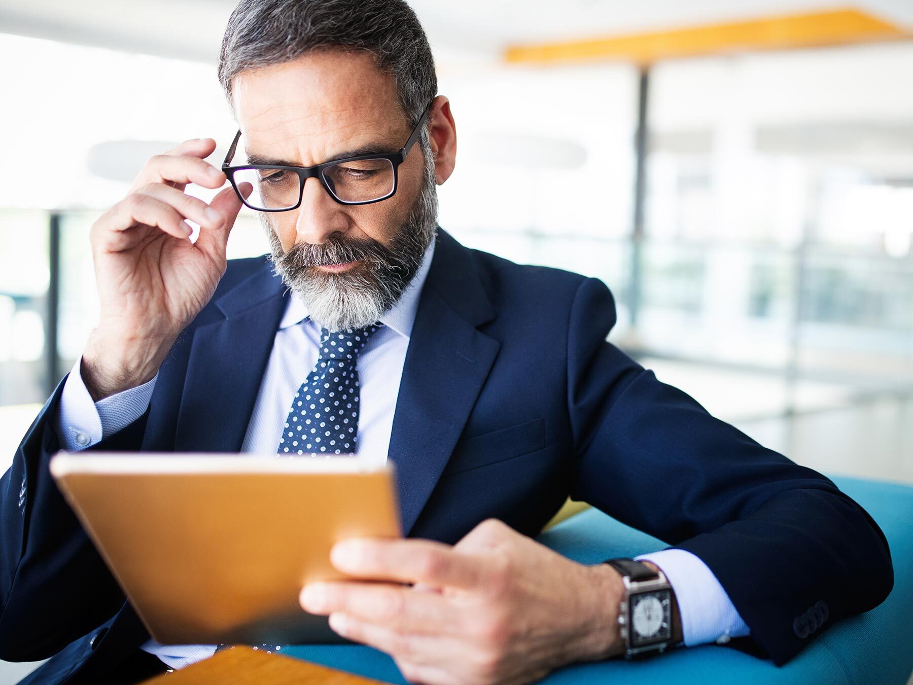 Mann guckt konzentriert auf iPad.